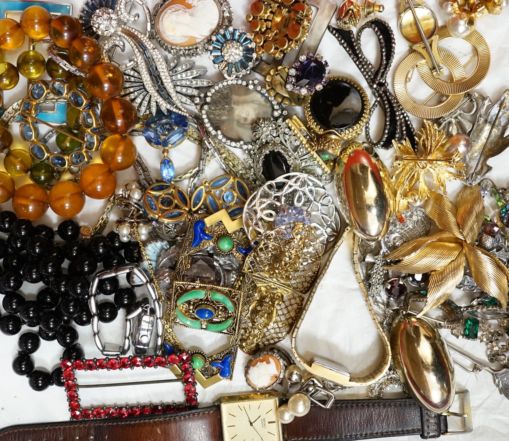 A large collection of costume jewellery, including a green and clear paste set necklace, a jet necklace, a silver and citrine cloak brooch, a yellow metal framed double portrait pendant, a yellow metal, enamel and rose c